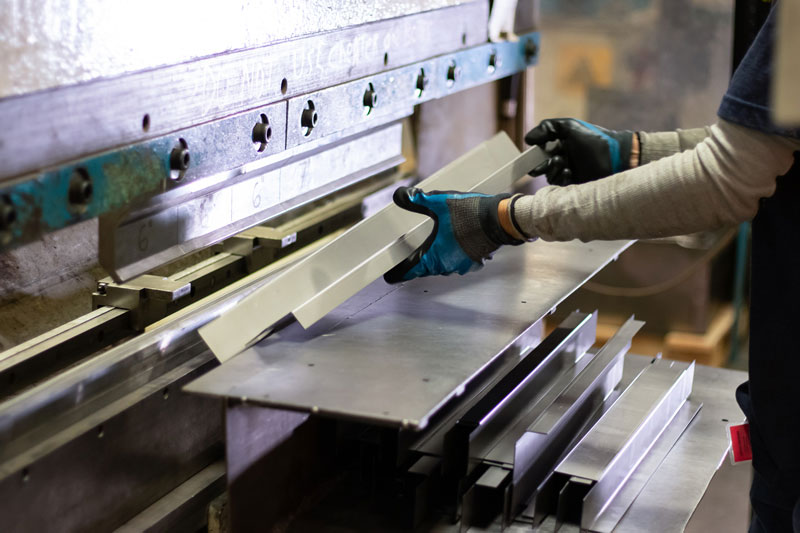 Lozier employee running a machine press in the Lozier plant