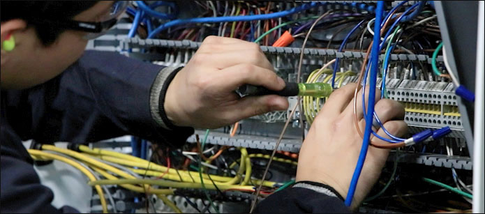 close up of Lozier employee working on wires and circuits