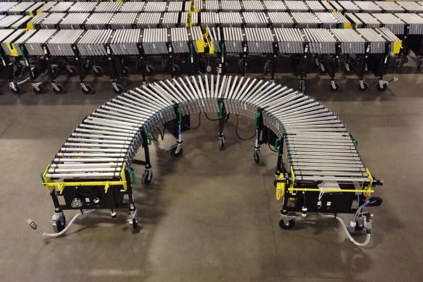 Casi Conveyor curled on warehouse floor.